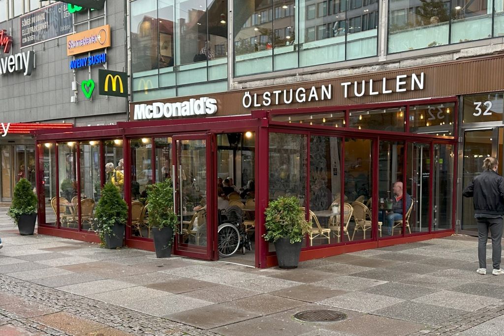 Inglasad uteservering på Avenyn i Göteborg med vinröda måttanpassade skjutdörrar | Sommar M50 glaspartier | Mekoflex