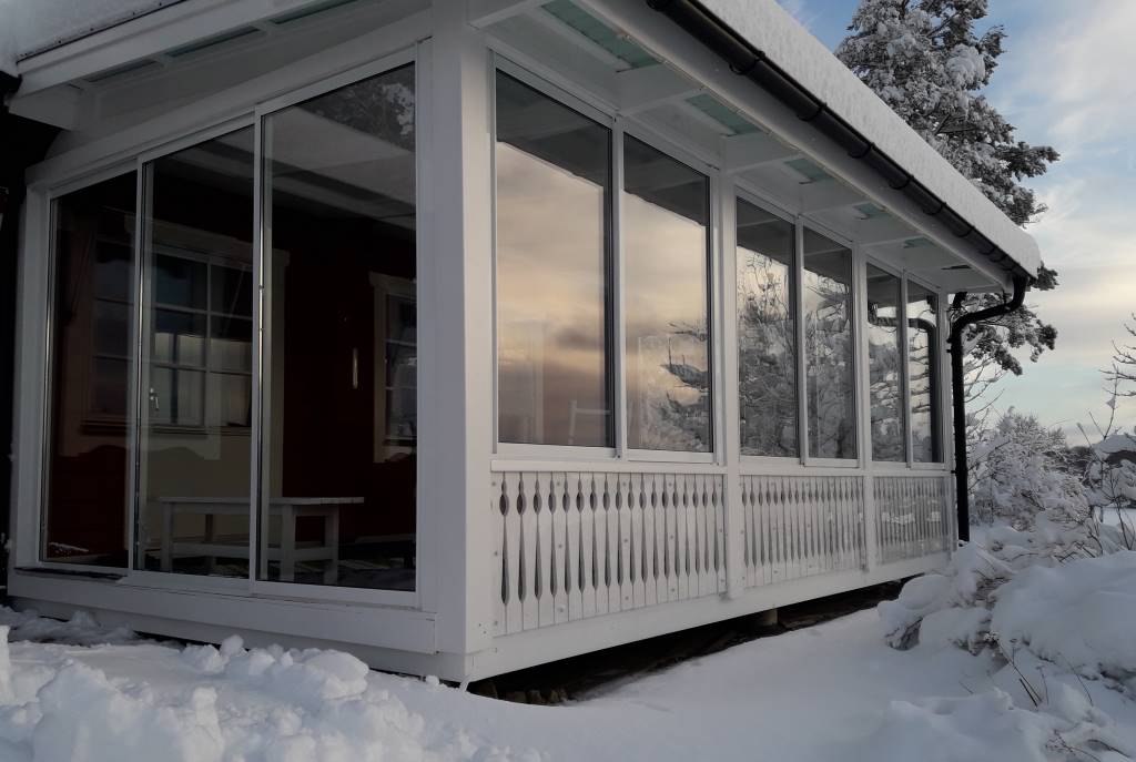 Skjutdörrar och skjutfönster på inglasat uterum i vinterskrud. | Mekoflex Uterum