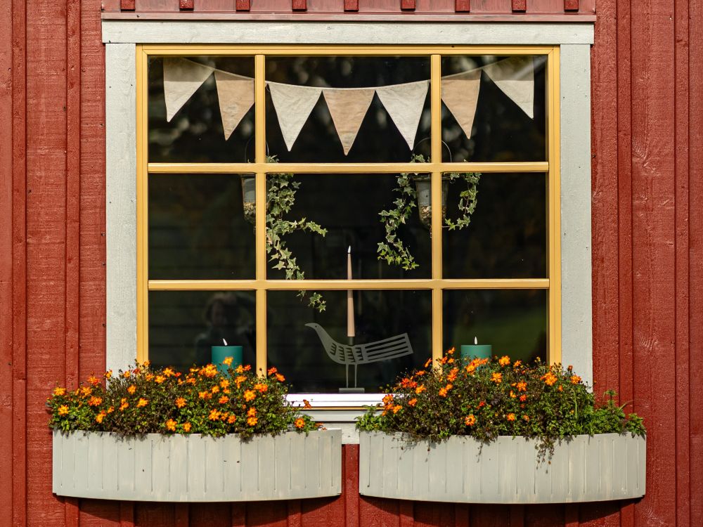 Charmigt fast fönster med spröjs och blomlådor skapar en varm och hemtrevlig fasad.<br>Fotograf Hanna Ämterlind. | Vår/Höst M70 glaspartier | Mekoflex Uterum