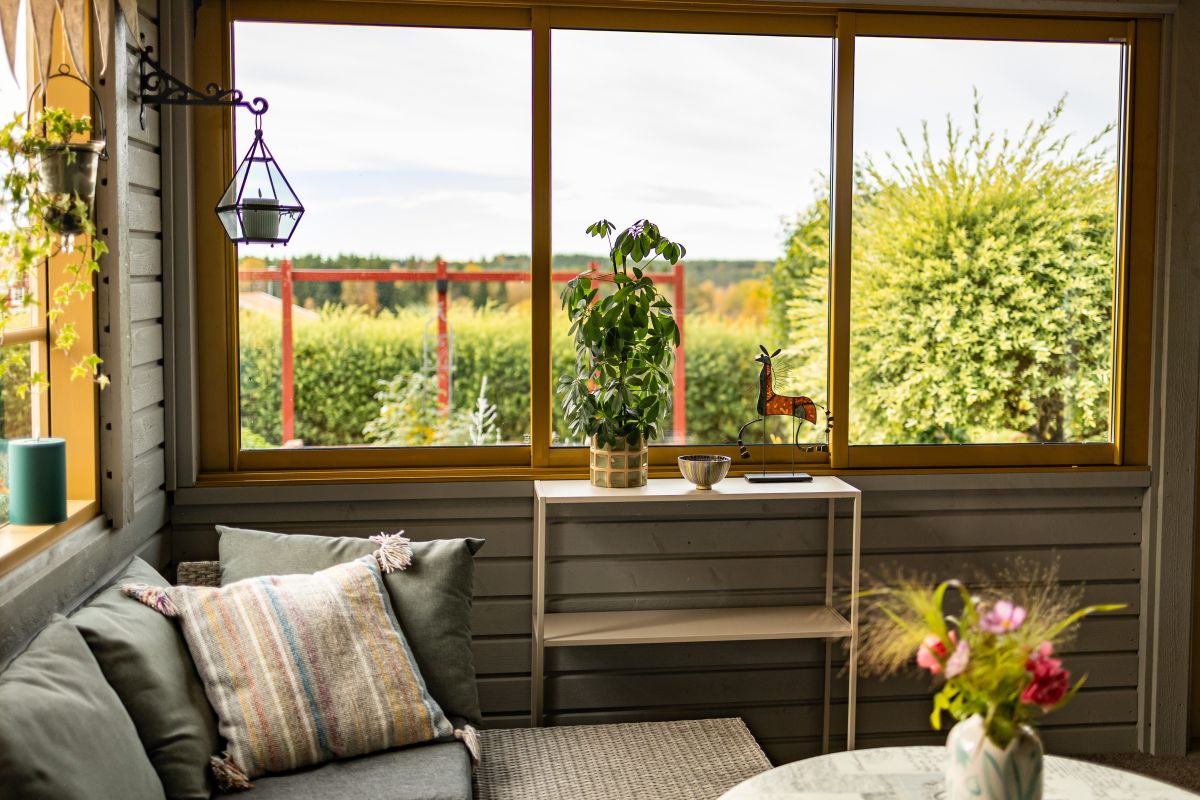 Inbjudande utsikt från uterummet där fönsterpartierna ramar in den frodiga trädgården.<br>Fotograf Hanna Ämterlind. | Vår/Höst M70 glaspartier | Mekoflex Uterum