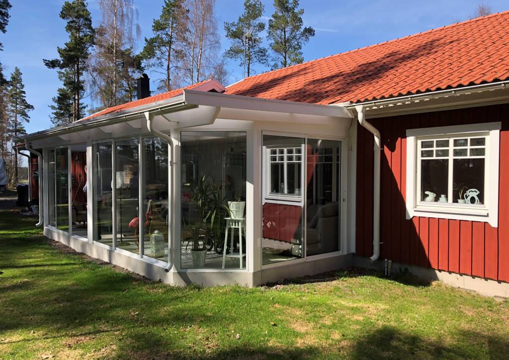 Fasadmonterat uterum med pulpettak i lantlig miljö med rikligt ljusinsläpp och stora fönster med vy över skog och trädgård. | Mekoflex Uterum